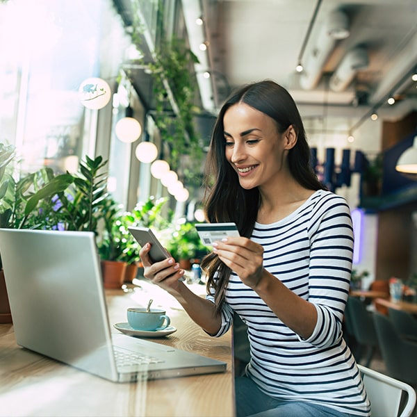 A female shopper entering her credit card information onto her mobile phone.