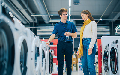 Un employé de boutique discute de la disposition des produit avec une cliente.